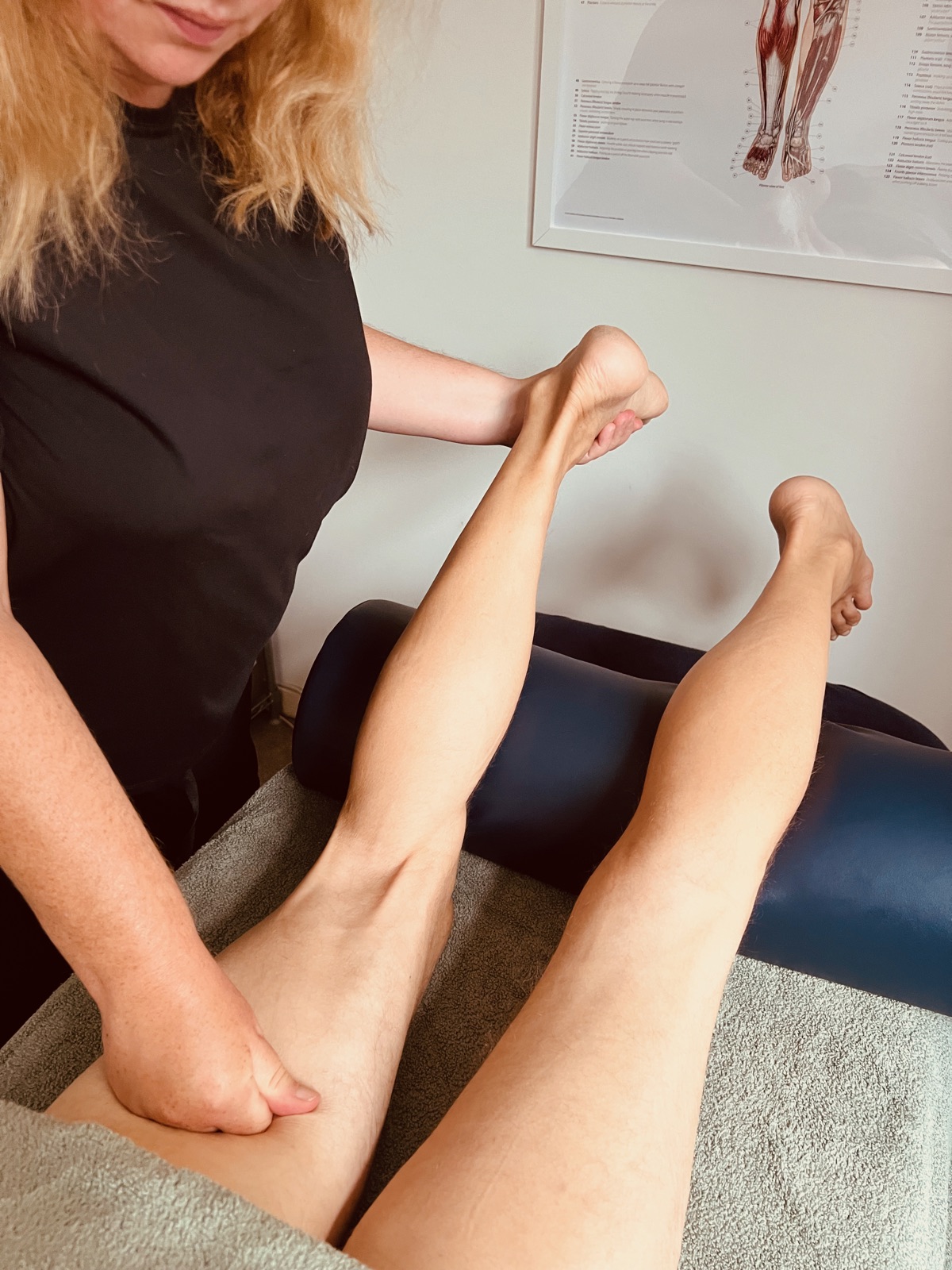 Cathy George treating a client's hamstring and lower leg