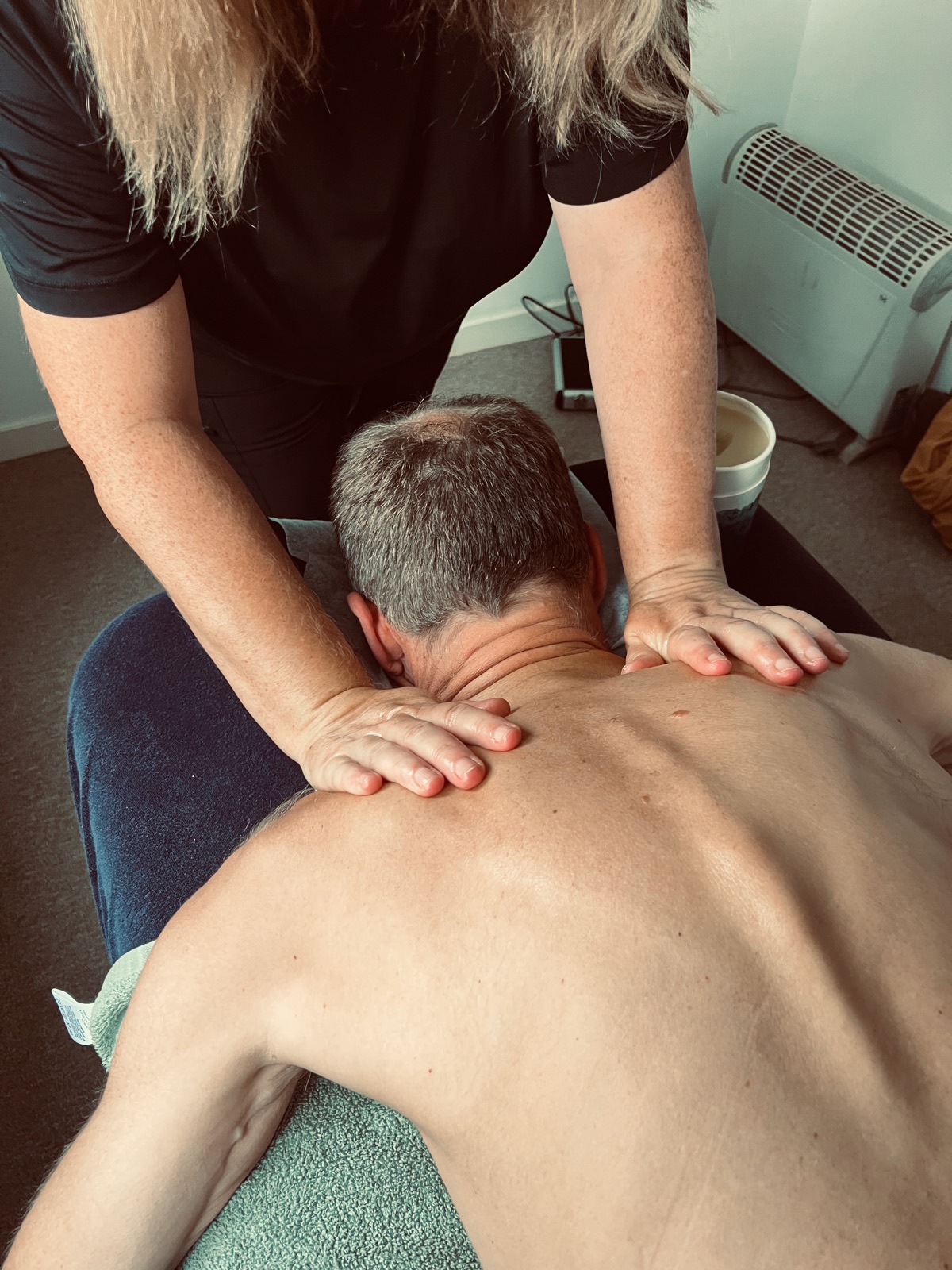 Cathy George working both hands across a client's neck and shoulders